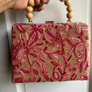 Colorful clutch with wooden beaded handle and gold chain.